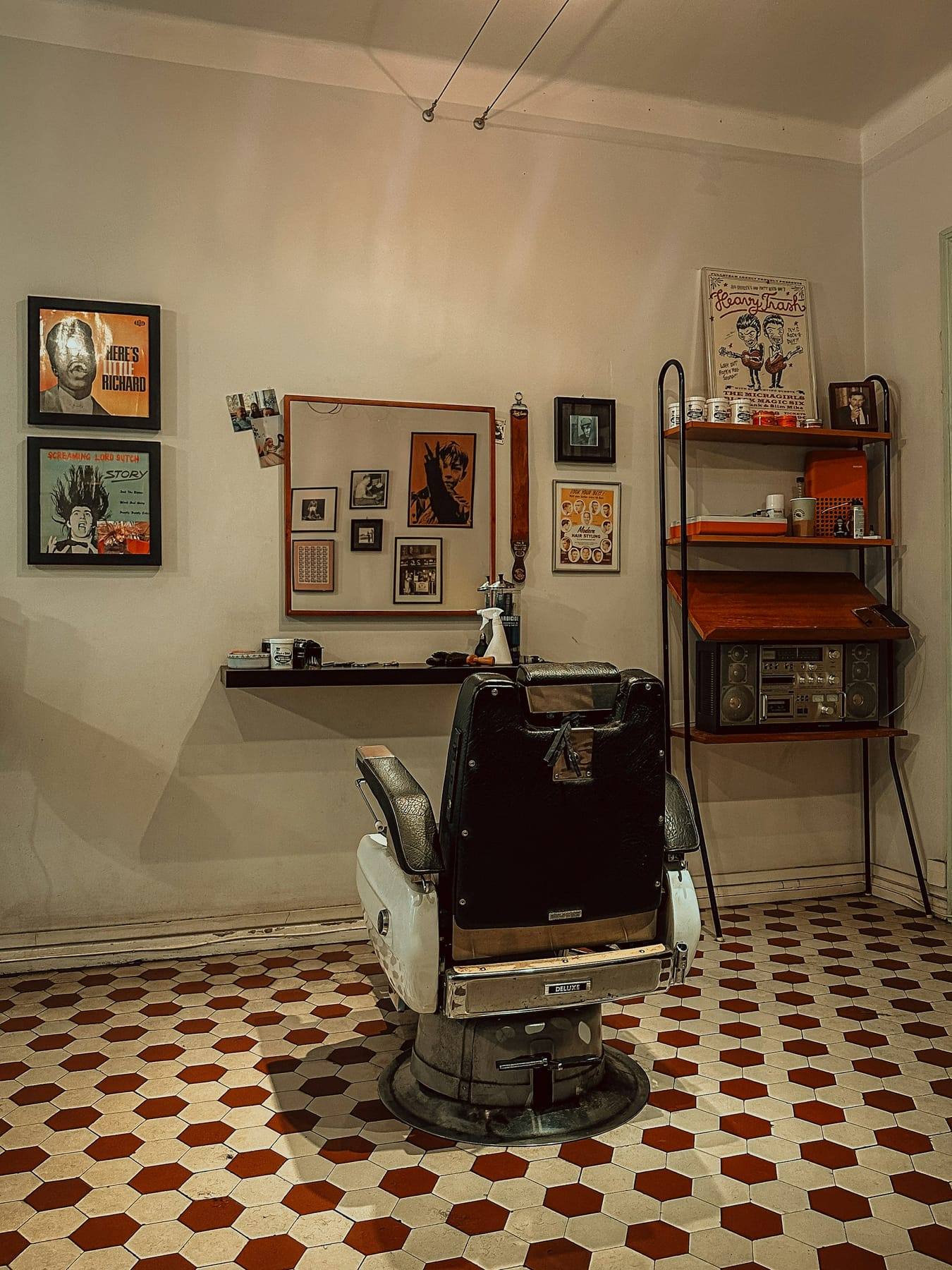 Vintage barber chair beside framed prints in the shop