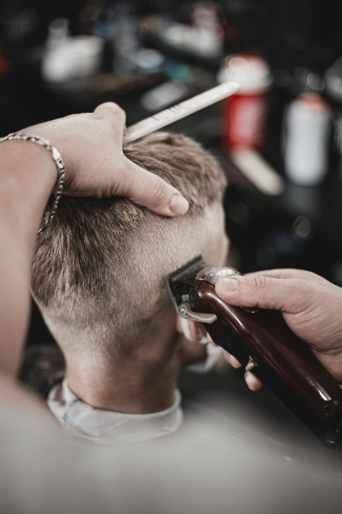 Barber blending a skin fade with clippers